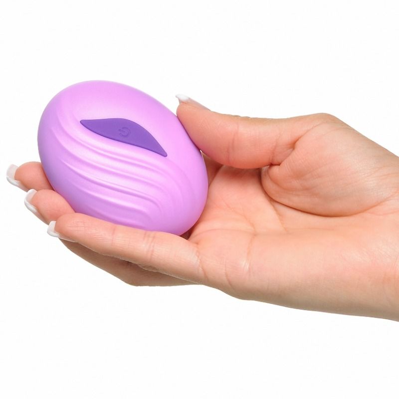 Panneau de commande du Stimulate-Her tenu en main, doigt sur le bouton d'allumage