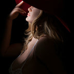 Poupée Bianca — portrait de profil avec chapeau rouge à large bord, éclairage dramatique