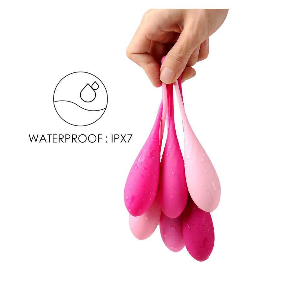 Trois boules de Geisha en silicone suspendues par leurs cordelettes degradees rose et fuchsia, demontrant l etancheite IPX7 et la souplesse du materiau