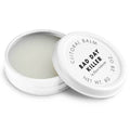 Baume clitoridien Bad Day Killer Bijoux Indiscrets, pot blanc ouvert laissant voir la texture cremeuse, couvercle pose a cote, cosmetique chauffant 8 g sur fond blanc