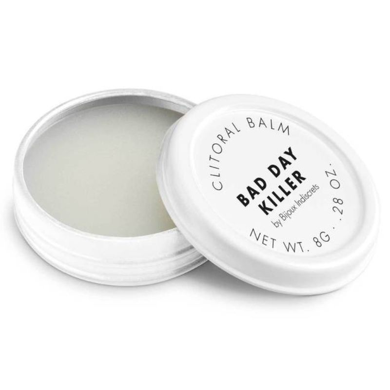 Baume clitoridien Bad Day Killer Bijoux Indiscrets, pot blanc ouvert laissant voir la texture cremeuse, couvercle pose a cote, cosmetique chauffant 8 g sur fond blanc