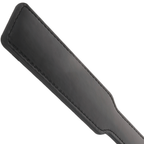 Vue rapprochee de la palette plate en cuir noir de la pagaie fetiche Darkness, surface rigide et coutures pour des impacts nets en discipline