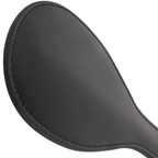 Vue rapprochee de la palette ronde en cuir noir de la pagaie fetiche Darkness, surface lisse et coutures pour une stimulation BDSM progressive
