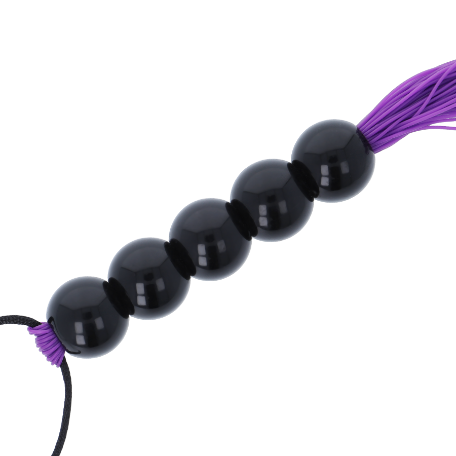 Gros plan sur le manche a perles noires lisses du fouet de bondage Darkness, billes brillantes alignees offrant une prise ferme et ergonomique en main.