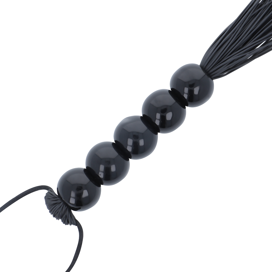 Detail du manche a perles noires lisses du fouet de bondage Darkness, billes brillantes assurant une prise sure pour un claquement precis et maitrise.