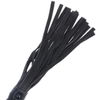 Gros plan sur les lanieres du flogger Darkness a manche cuir, faisceau de meches plates noires du fouet de discipline BDSM pour la domination.