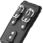 Detail des deux boucles metalliques et de la doublure fausse fourrure d'une large menotte Darkness en cuir PVC noir, ajustement precis pour le poignet.