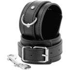 Menotte Darkness en cuir noir avec boucle reglable, anneau en D et double mousqueton argente, accessoire de bondage souple pour debuter la restriction.
