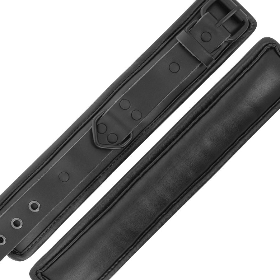 Sangles de cuir noir a boutons-pression argentes du kit Darkness Sub & Dom, montrant les surpiqures et la doublure souple des manchettes de bondage.