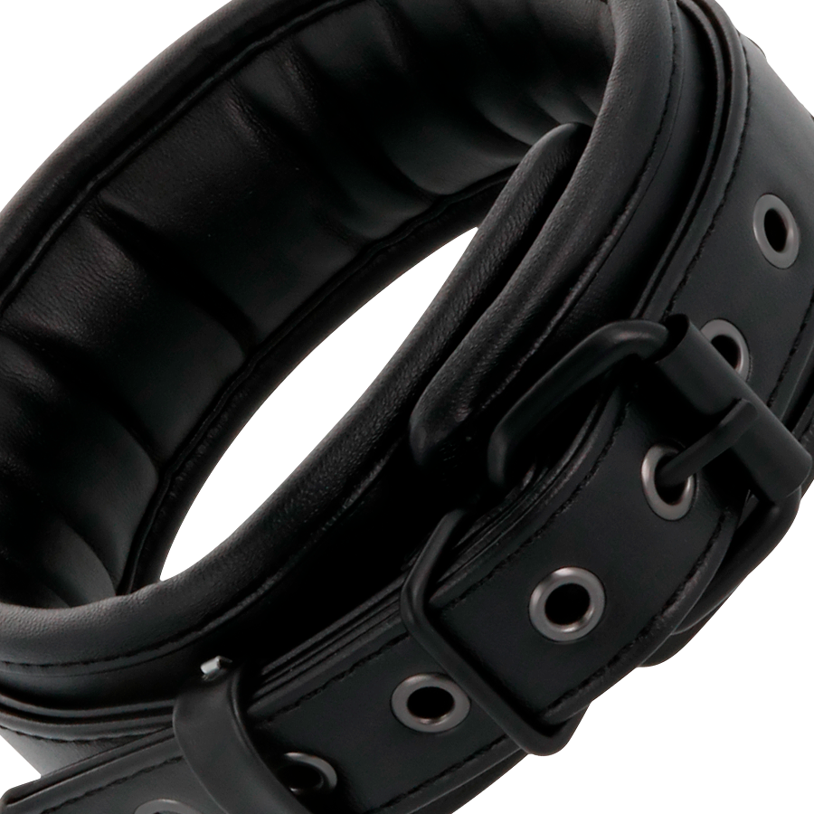 Collier de soumission Darkness en cuir noir rembourre a oeillets metalliques et boucle, point central du kit Sub & Dom pour la domination en couple.