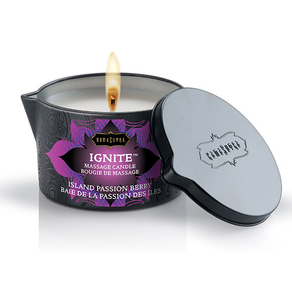 Bougie de massage Kamasutra Ignite Island Passion Berry allumee, flamme vive et couvercle metallique a cote, cire au karite et vitamine E qui fond en huile de massage.