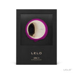 Boite Lelo Ora 3 de face, simulateur de plaisir oral fuchsia presente sous fenetre, disque rotatif dore en silicone, mention oral pleasure simulator sur l'emballage noir premium.