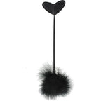 Tapette en forme de cœur associée à un plumeau noir, accessoire BDSM sur fond blanc