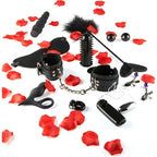 Vue d'ensemble des 10 accessoires du kit : menottes, fouet, masque, pinces à tétons, vibrateur et bouchon anal, disposés parmi des pétales de rose