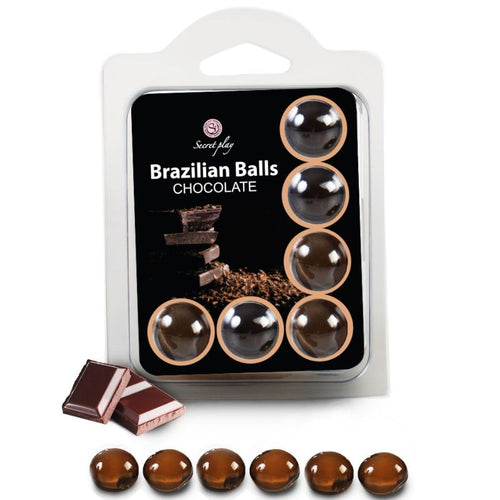 Boules bresiliennes aromatisees chocolat Secret Play, blister de six billes brunes solubles a coeur huileux comestible, packaging avec carres de chocolat, fondent a la chaleur.