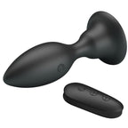 Plug anal Mr Play en silicone noir couche pres de sa telecommande ovale a trois boutons, forme conique a col resserre, 12 modes de vibration etanches rechargeables USB.