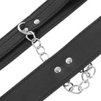Gros plan sur la sangle en cuir texture noir Darkness avec rivets, chaine argentee et anneau, detail des menottes reglables conçues pour le bondage et la domination.