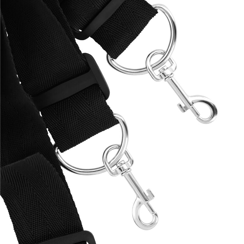 Gros plan sur les mousquetons argentes et la sangle neoprene noir du kit d'attaches de lit Darkness, systeme de connexion rapide pour les jeux de restriction au lit.
