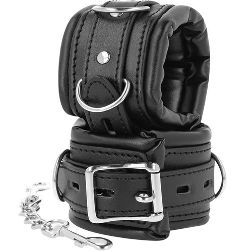 Paire de menottes BDSM Darkness en simili cuir noir double epaisseur rembourre, anneau D, boucle robuste et chaine, accessoire de restriction confortable pour les poignets.