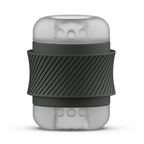 Masturbateur compact Bhandy : gaine translucide texturée serrée dans un manchon noir antidérapant. Vue de face du cylindre, texture interne visible, aucun moulage réaliste.