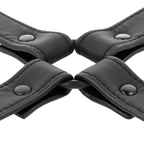 Detail du croisement central capitonne du hogtie Fetish Submissive, sangles en cuir vegan noir matelassees reunies par boutons pression metal pour repartir la tension du bondage.