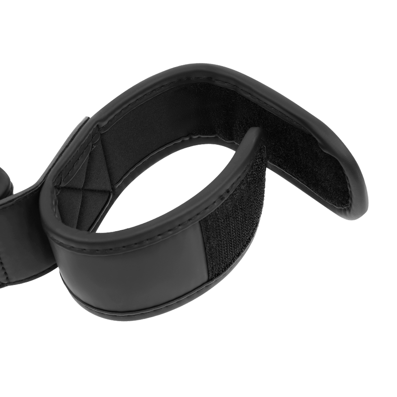 Manchette velcro enroulee de la barre d'ecartement Fetish Submissive vue de trois quarts, neoprene noir rembourre et bande de serrage souple