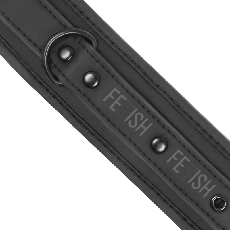 Detail de la sangle reglable d'une manchette cuir vegan Fetish Submissive, boutons-pression et logo grave sur le bracelet neoprene noir
