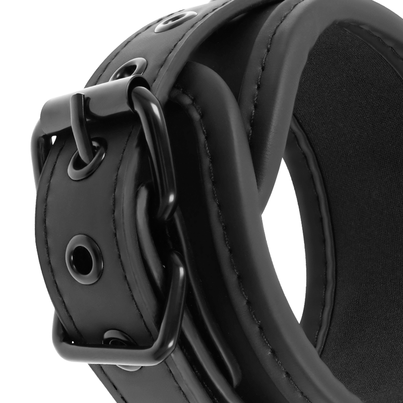 Macro de la boucle metal noir et anneau en D sur une manchette neoprene du harnais maitre Fetish Submissive, cuir vegan reglable