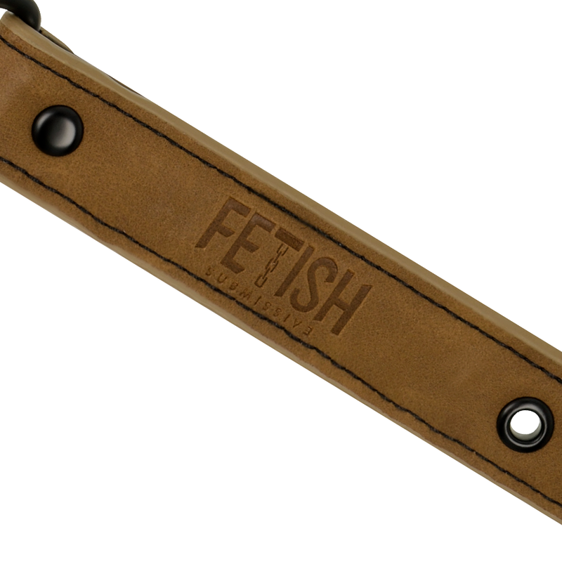 Detail de la sangle cuir vegan camel du baillon Fetish Submissive, logo grave et oeillet metal, laniere reglable pour un maintien confortable en jeu BDSM.