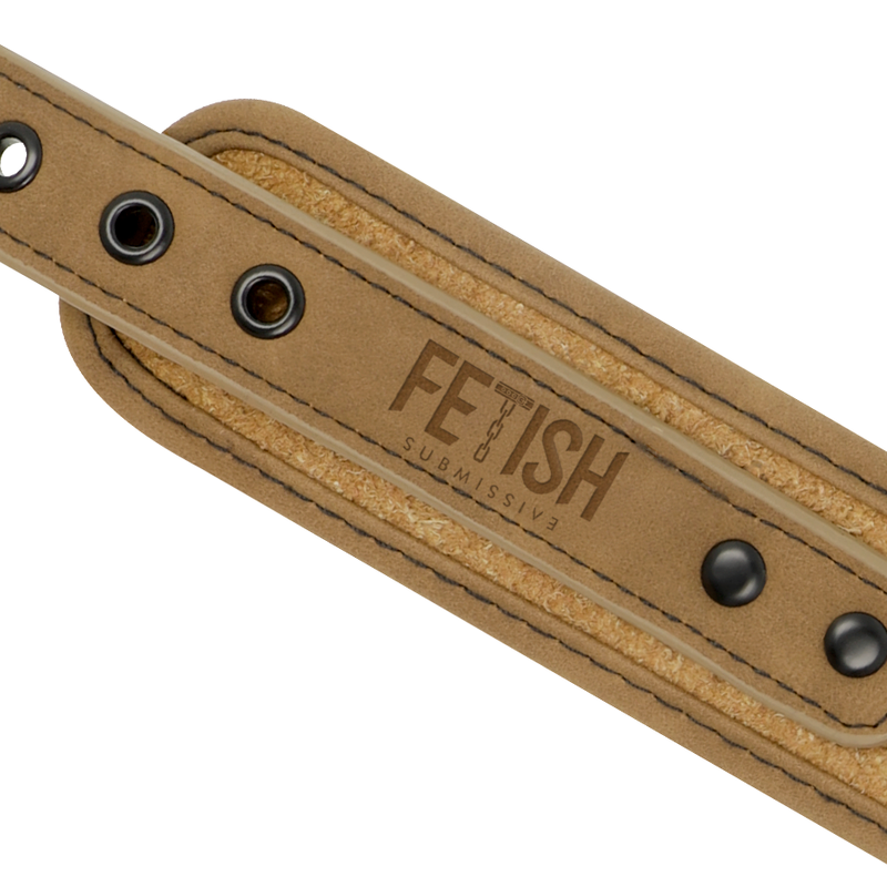 Gros plan sur le logo grave et les rivets metal noir de la sangle en cuir vegan camel du collier Fetish Submissive, finition soignee pour le jeu de soumission.