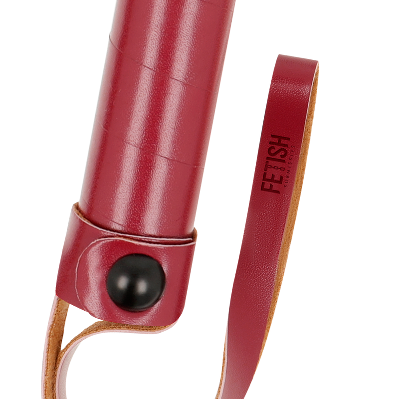 Gros plan du manche cuir vegan bordeaux du flogger Fetish Submissive avec bouton pression metal et dragonne, detail de la poignee ergonomique pour la discipline.